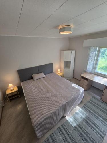 a bedroom with a large bed and a window at Revontulet ZH Tulimetsän Kylä in Pieksämäki
