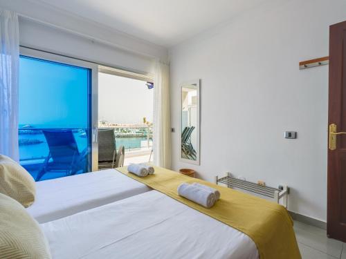 a bedroom with a large bed and a large window at HolaMogamar in Puerto de Mogán