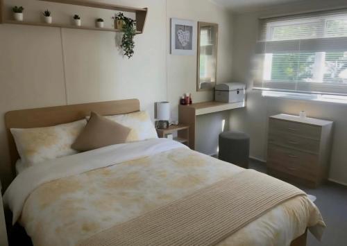 a bedroom with a large bed and a window at Seashells - Exclusive Private Area to Side in Coldingham
