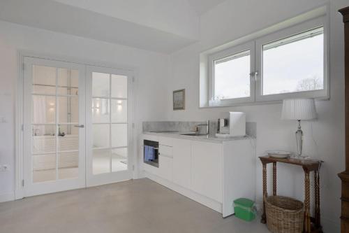 a white kitchen with a sink and a window at Bij Oriënshuis in Varsseveld