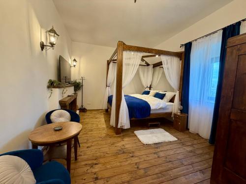 a bedroom with a canopy bed and a table at Malom Loft Apartman in Veszprém