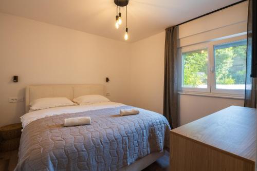 a bedroom with a bed with two pillows on it at Tembo Apartment in Sinj