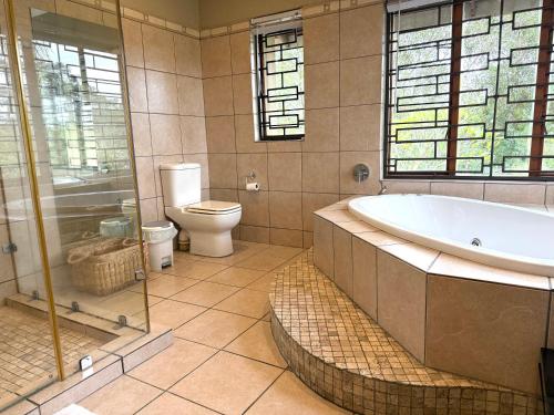 a bathroom with a tub and a toilet at The Sanctuary- Self Catering Accommodation in Nelspruit