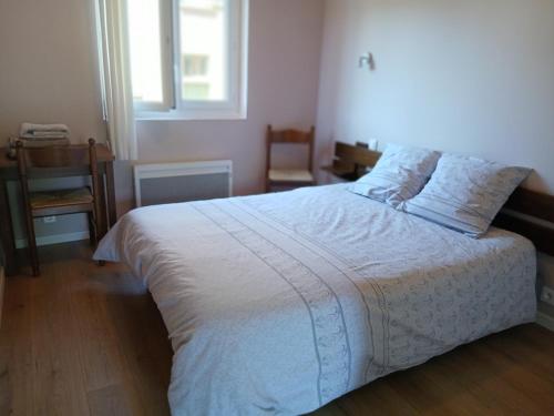 a bedroom with a white bed and a window at Hôtel de Cenves in Cenves