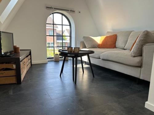 een woonkamer met een bank en een tafel bij Luxe Tiny House Ooij in Ooij