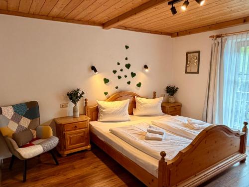 a bedroom with a large bed and a chair at Bergbauernhof Leitenlehen in Berchtesgaden