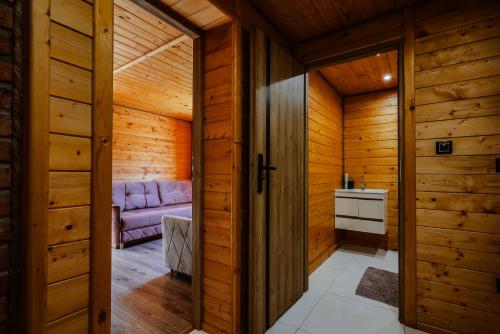 a sauna with a purple couch in a wooden room at Stachowa Chata Guciów in Guciów