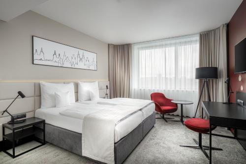 a hotel room with a large bed and a desk at Clarion Congress Hotel Prague in Prague