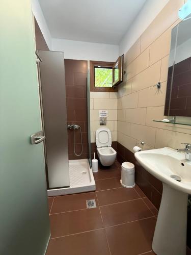a bathroom with a shower and a toilet and a sink at Dolphins House in Koinyra