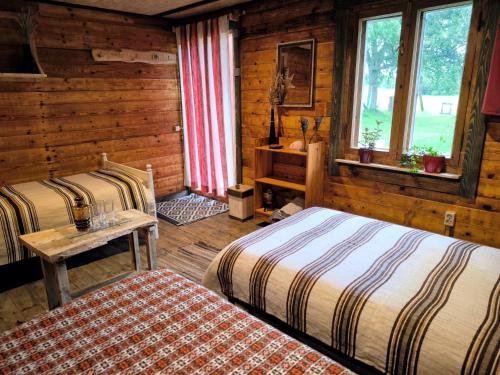 a bedroom with two beds in a log cabin at Barn Suite in Valga