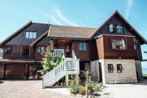 a large wooden house with a staircase in front of it at Surf Lodge South Africa in Jeffreys Bay