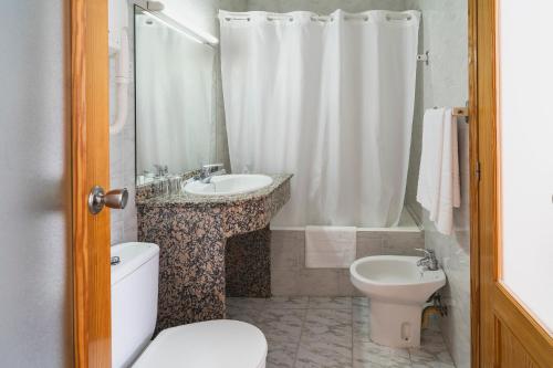 a bathroom with a toilet and a sink and a shower at Hotel Amic Can Pastilla in Can Pastilla