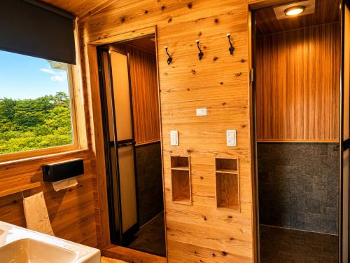 ein Badezimmer mit Dusche und Waschbecken in der Unterkunft RENEST in Kōbe