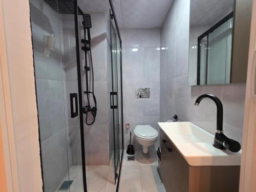 a bathroom with a shower and a toilet and a sink at Ada Park Hotel in Kuşadası
