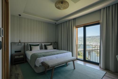 a bedroom with a large bed and a balcony at Quinta do Roso - Douro Wine Estate - by FERO in Lamego