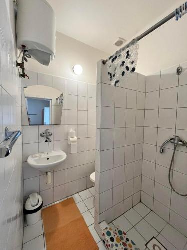 a white bathroom with a shower and a sink at Ubytovanie Klára in Veľký Meder