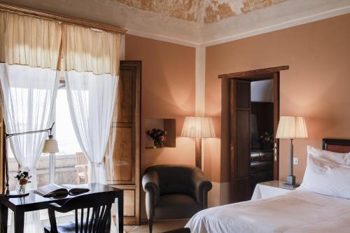 a bedroom with a bed and a chair and a desk at Mà C'a - Casa Privata in Praiano