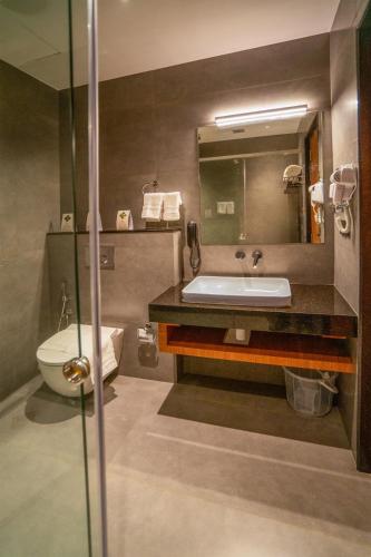 a bathroom with a sink and a toilet at HOTEL MARIAPARK KALLooRKKAD in Vāzhākulam