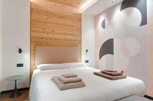 a bedroom with a white bed with wooden walls at Apartments Trettel in Tesero