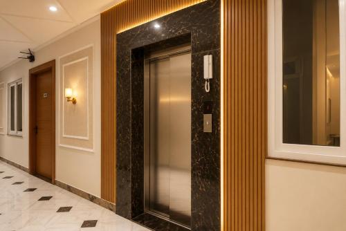 a hallway with a glass elevator in a building at Hotel Shree Near Prem Mandir in Chhatikara