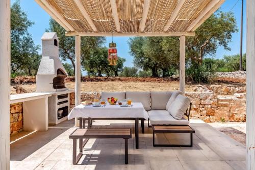 a patio with a couch and a table and an oven at Lamia Terra 3BR, Terrace & BBQ - Happy Rentals in Castellana Grotte