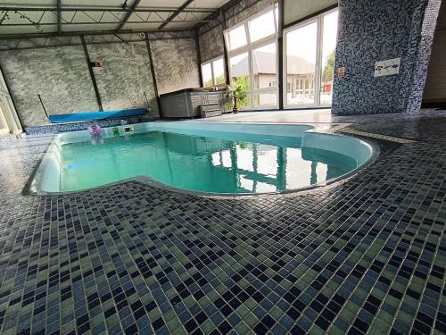 a swimming pool in a building with a tile floor at Domki Helena Okuninka in Okuninka