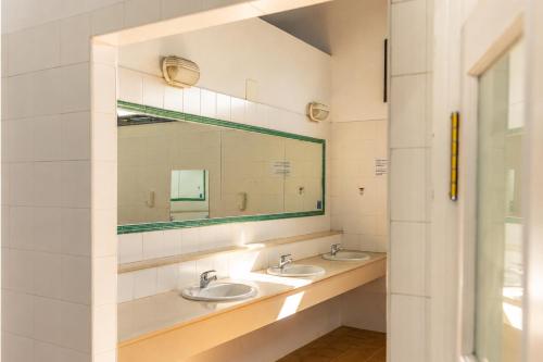 a bathroom with two sinks and a mirror at Kampaoh El Rocío in El Rocío