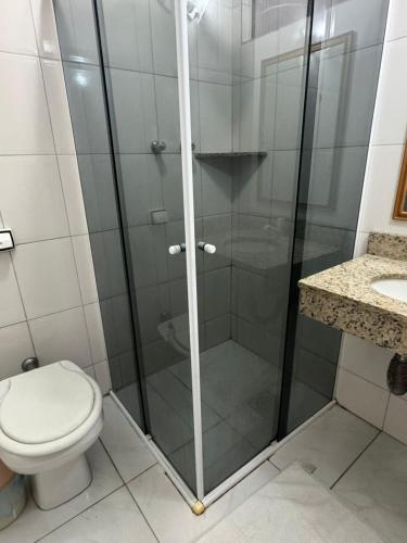 a bathroom with a shower with a toilet and a sink at Hotel Lisboa II in São José dos Campos
