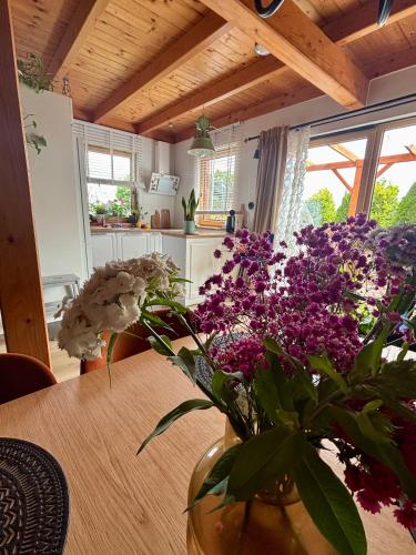 a vase of purple flowers sitting on a table at Żuławska Osada in Trutnowy