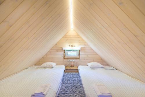 a bedroom with two beds in a wooden house at Reiu majake in Reiu