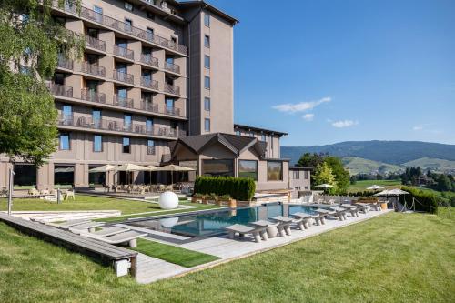 ein Hotel mit Schwimmbad und einem Gebäude in der Unterkunft Linta Hotel Wellness & Spa in Asiago