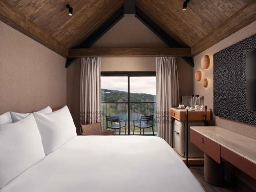 a bedroom with a large bed and a balcony at Ceylan Splend'or Uludag, Autograph Collection in Uludar