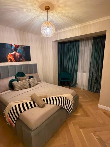 a bedroom with a large bed and a chandelier at GZP Residence Lugoj 5 in Lugoj