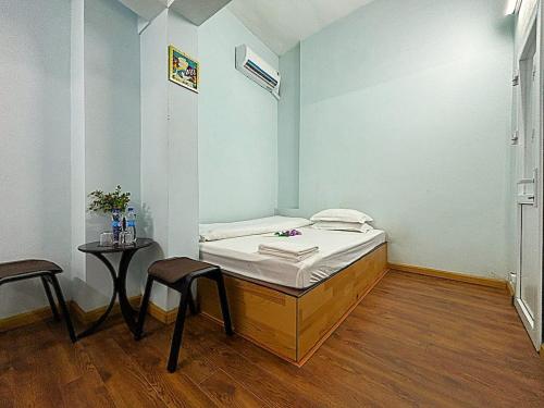 a room with a bed and a table and chairs at Homestay Chân Mây in Tam Ðảo