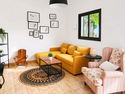 a living room with a yellow couch and two chairs at Casa del Parque Tacoronte Centro in Tacoronte