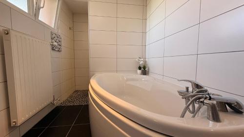a bath tub in a bathroom with a sink at Maison HELIOS - Eguisheim in Eguisheim