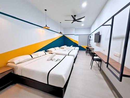 a row of beds in a room with a ceiling fan at Smile Hotel Wangsa Maju in Kuala Lumpur