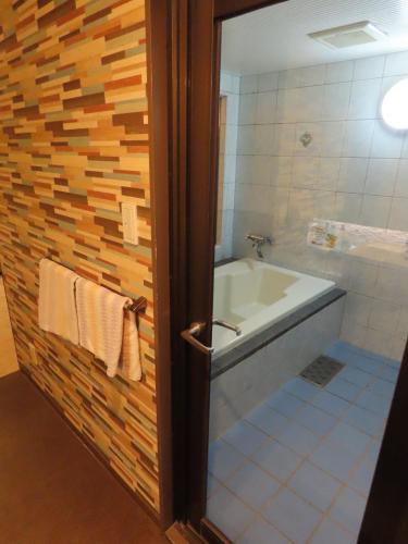 a bathroom with a bath tub and a sink and a shower at 名古屋北区のホテルコアラ in Tsujichō