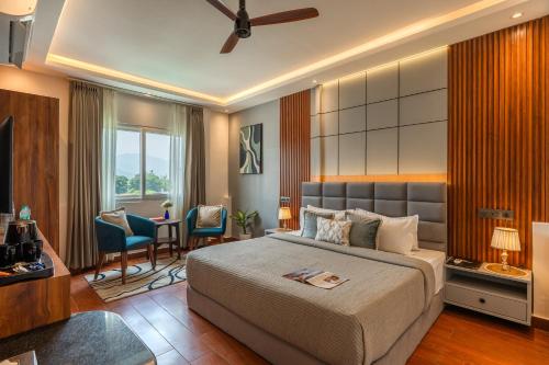 a bedroom with a bed and a desk and chairs at Perfectstayz AIIMS near Aiims Hospital in Rishīkesh