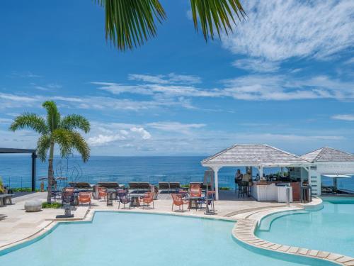 a swimming pool with a view of the ocean at La Toubana Hotel & Spa in Sainte-Anne