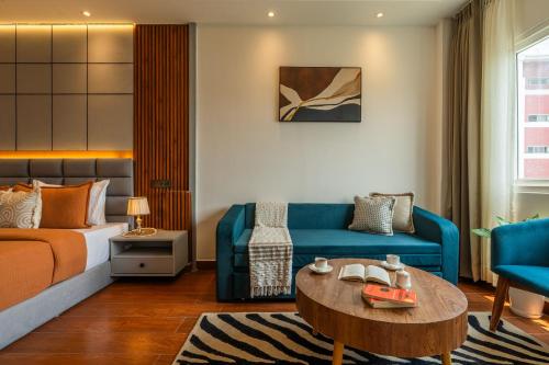a hotel room with a bed and a couch and a table at Perfectstayz AIIMS near Aiims Hospital in Rishīkesh