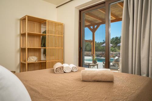 a bedroom with a bed with towels on it at Alestone Villa by the sea in Vasilikos