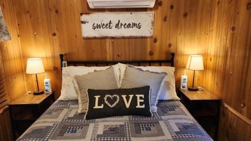 a bedroom with a bed with alove pillow on it at The Couple's Cabin in Wynola 2 NIGHT MINIMUM in Julian