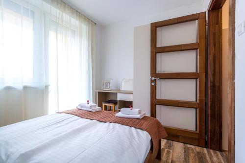 a bedroom with a bed with two towels on it at Aqualiget-Apartmanház E-Car plug-in point Szeged in Szeged