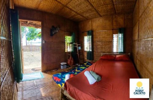 a bedroom with a bed in a room with a window at Point Calixto beach front hut, Boracay in Boracay