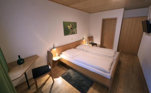 a bedroom with a bed and a table and a desk at Gästehaus am Westtor in Prichsenstadt