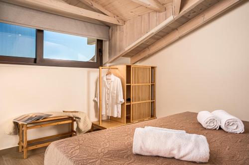 a bedroom with a bed with towels on it at Alestone Villa by the sea in Vasilikos