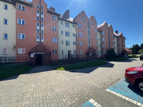 a row of buildings with a red car parked in front at Apartament W15B in Koszalin
