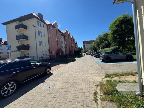 a street with cars parked in a parking lot at Apartament W15B in Koszalin
