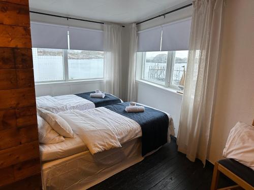 a bedroom with two beds in front of a window at Astra Whale - Waterfront Boutique Hostel in Lofoten in Kabelvåg